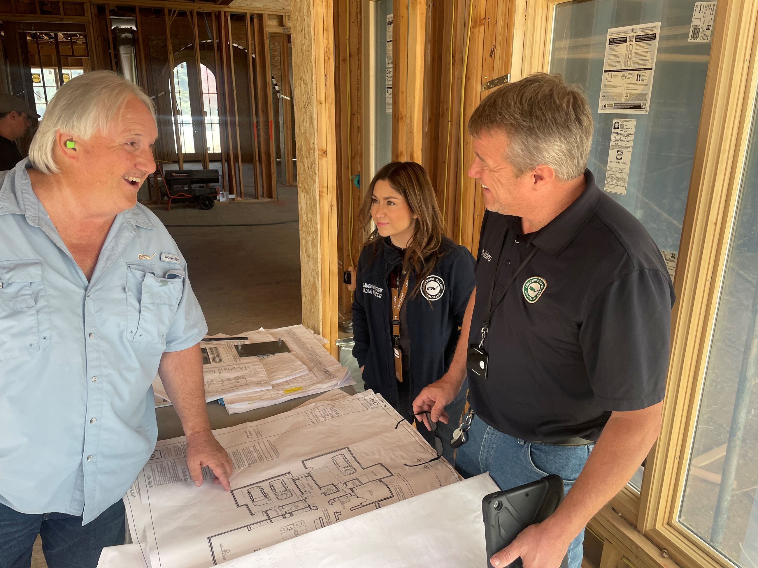 Three building inspectors review site plans.