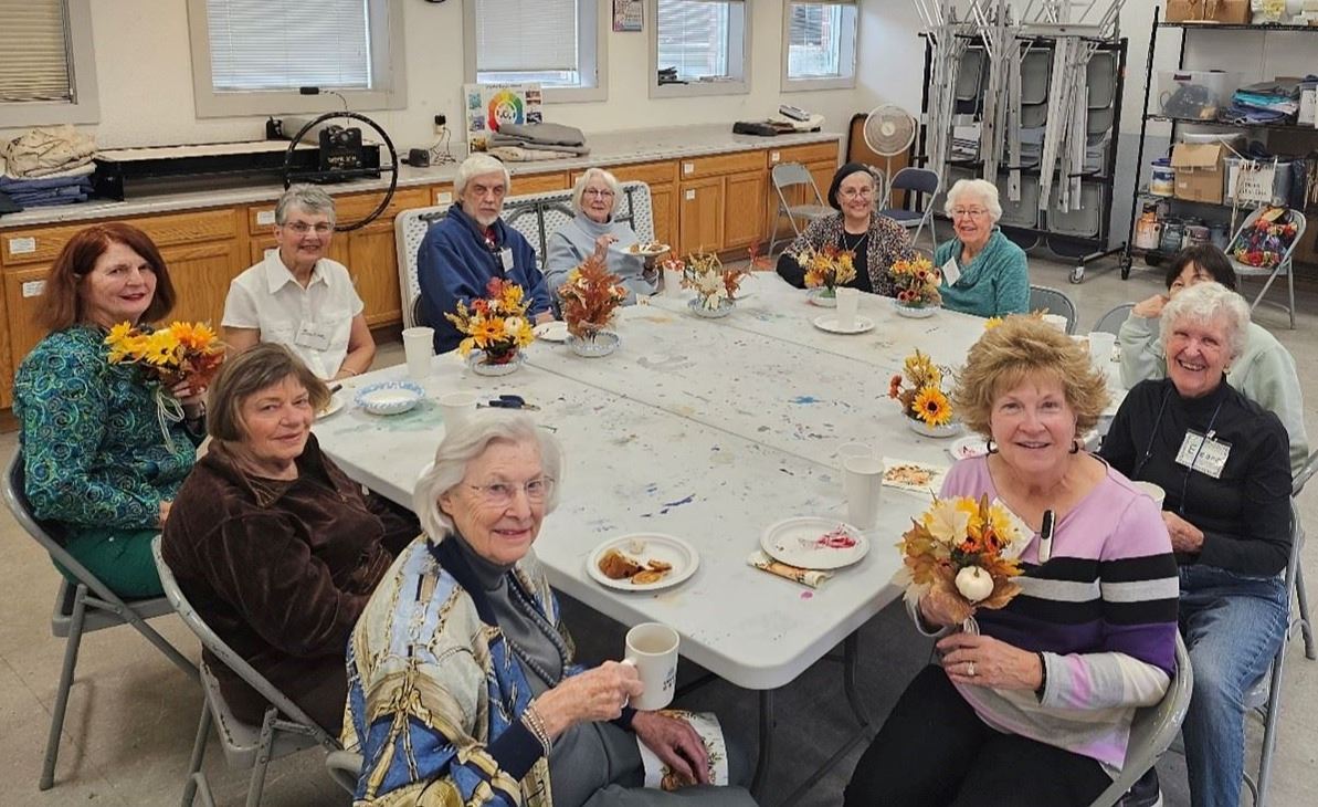 Senior adults around a square table painting