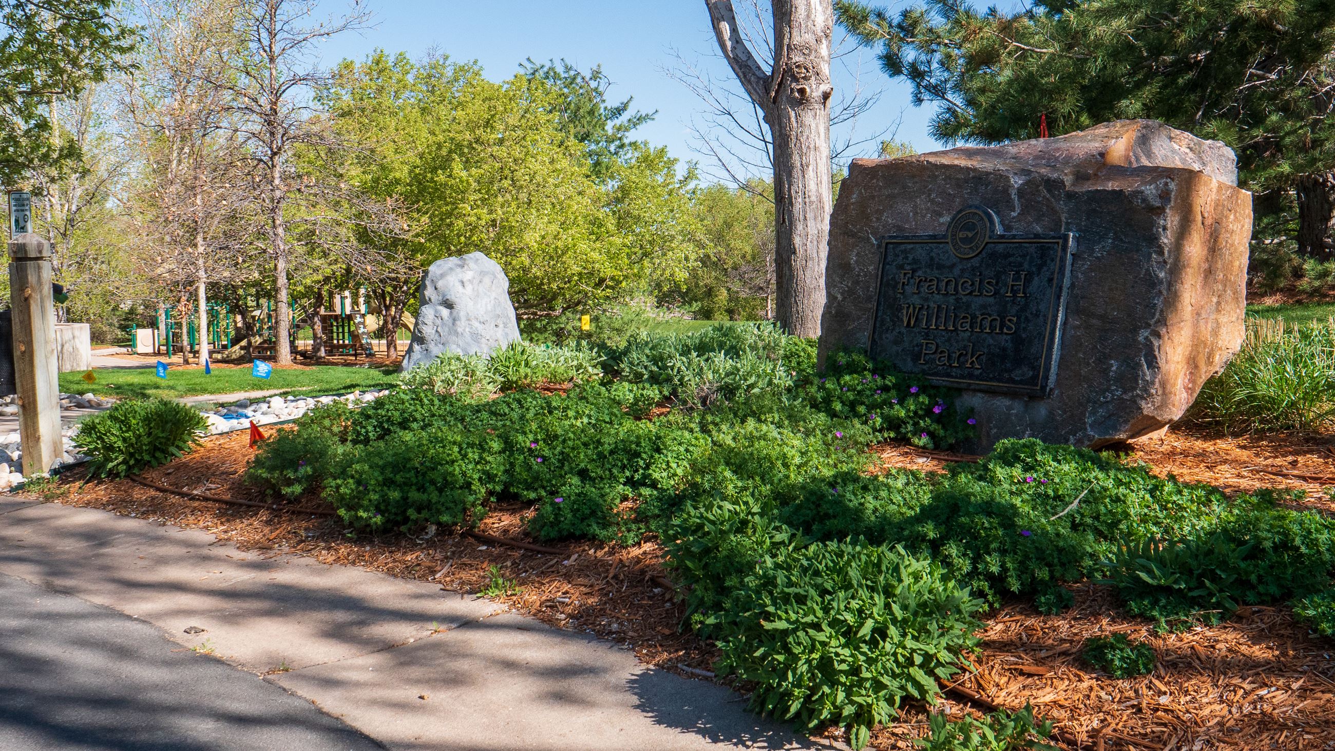 Garden area with large rock sign reading Francis Williams Park